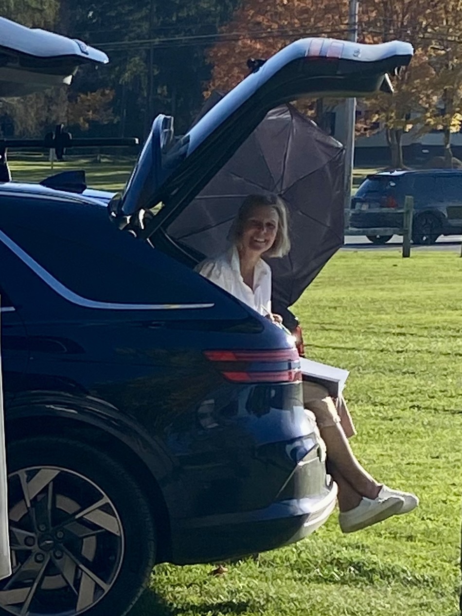 Jennifer seated in the open trunk of her car